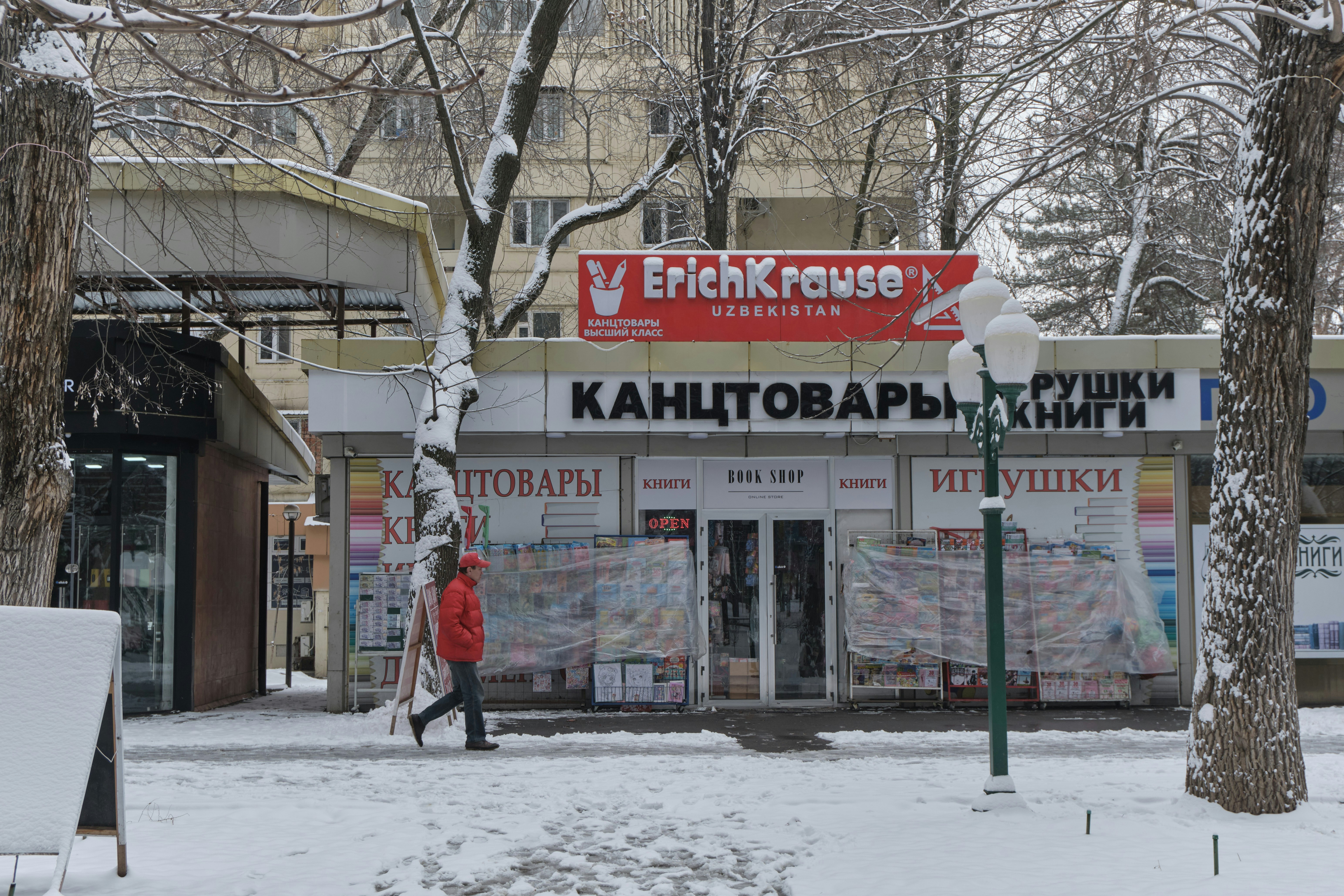 A person walks past a store on a snowy day
