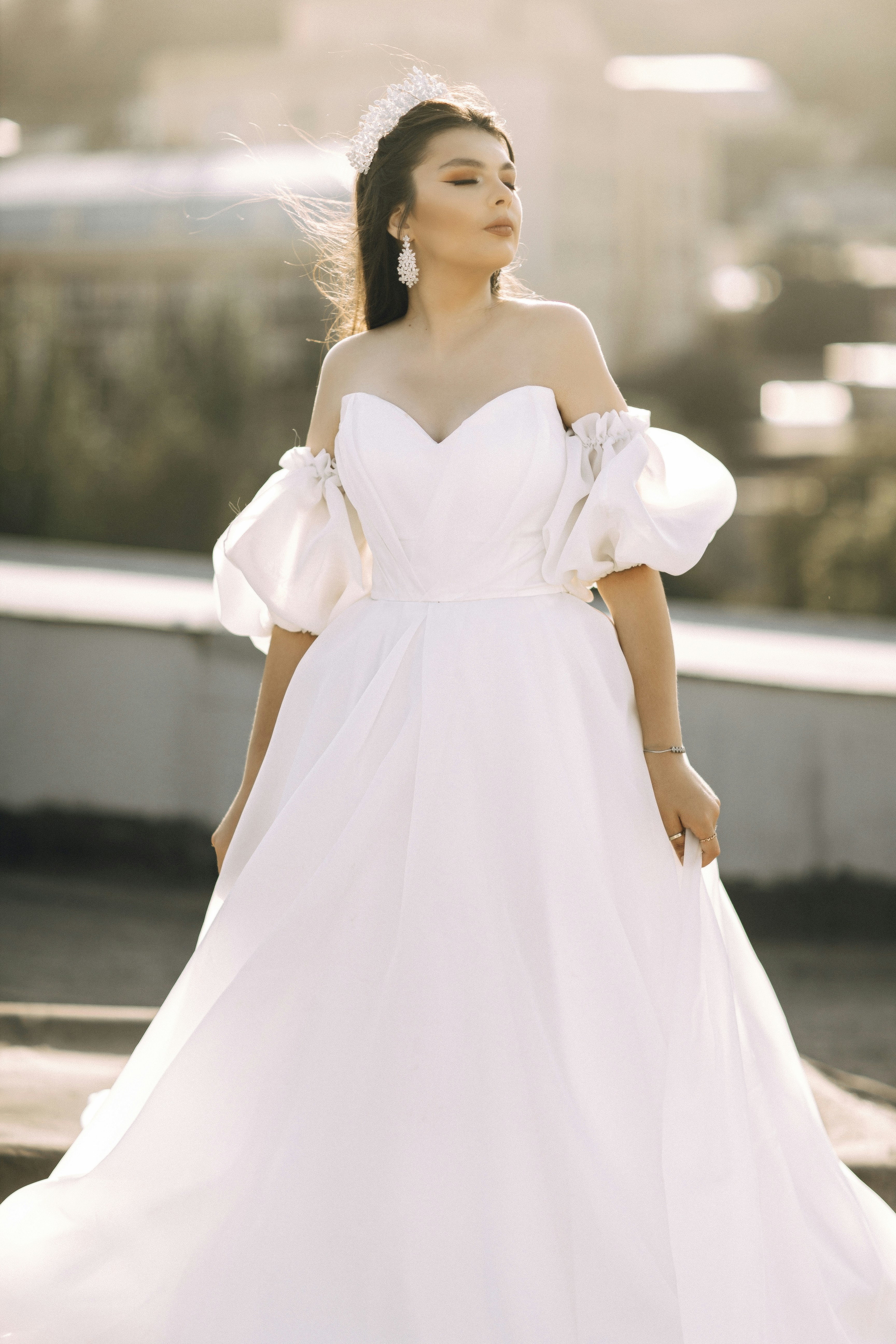 A woman poses in a white wedding dress.