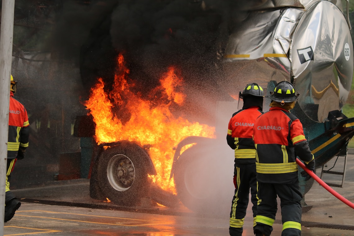 Firefighters extinguish a burning truck's tire.