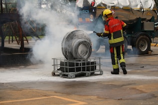 A firefighter extinguishes a burning tire with water.