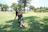 Woman relaxes on grass in a sunny park.