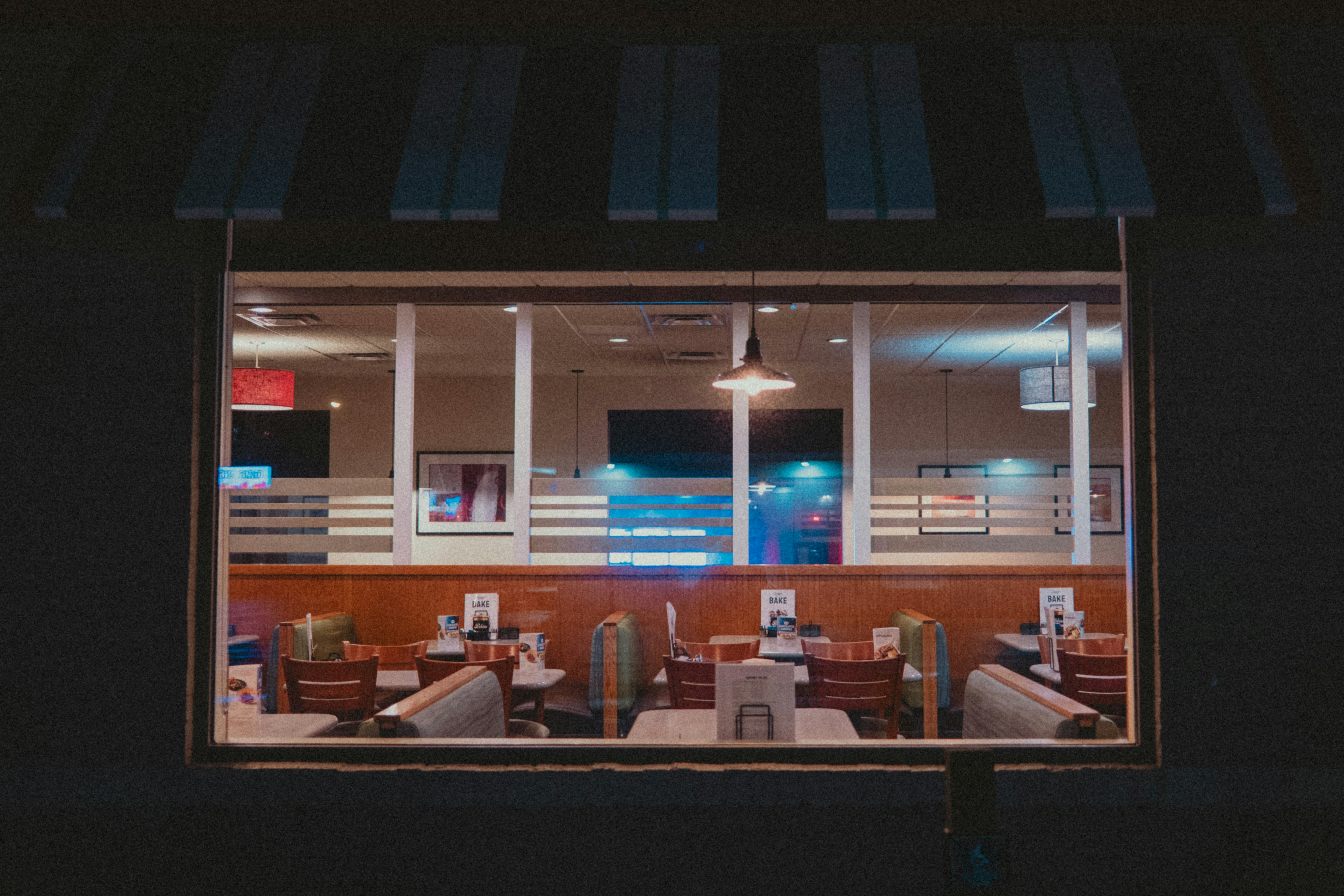 A diner's interior is seen through its windows