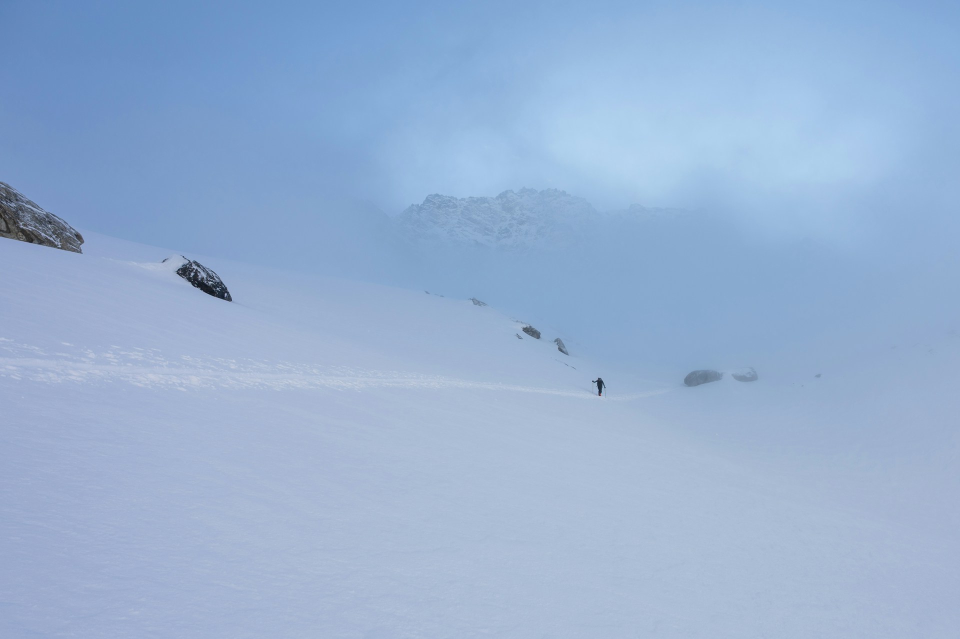 A person skis across snowy mountain.