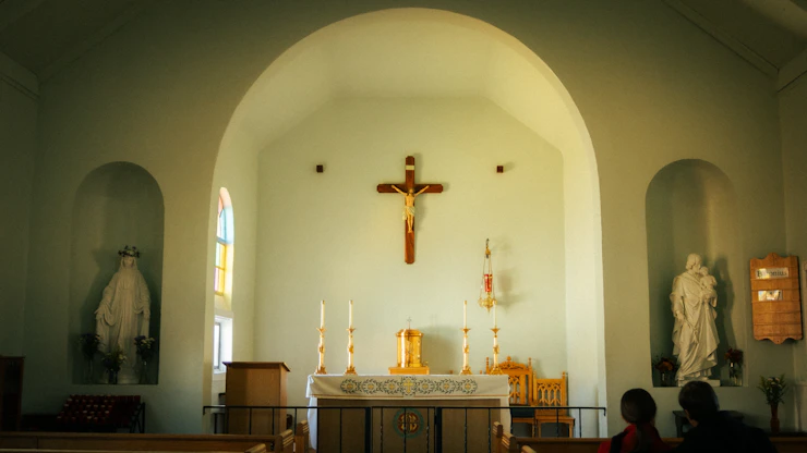 A church interior with a crucifix and religious statues.