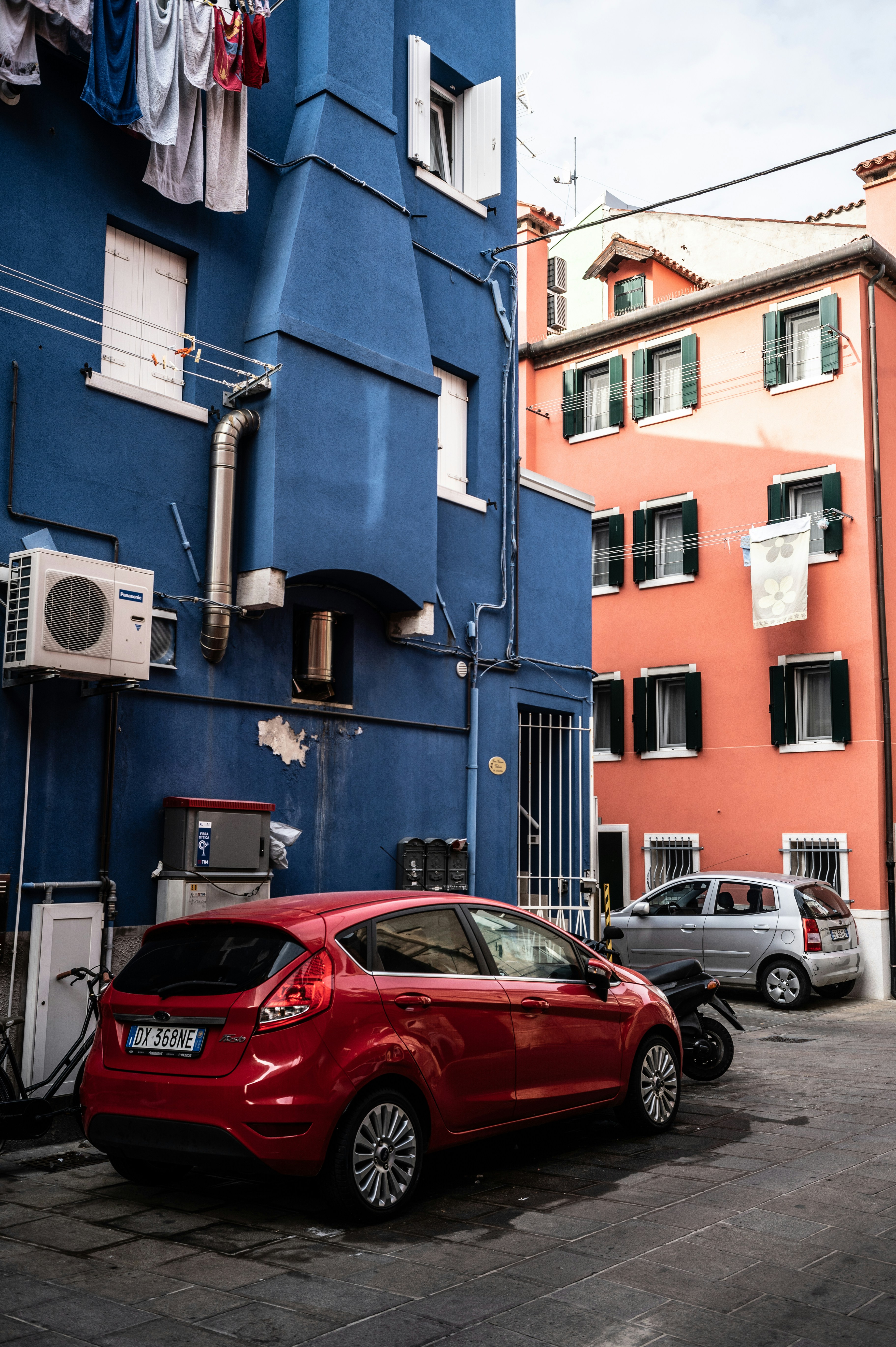 Edifici colorati e auto riempiono una strada stretta.