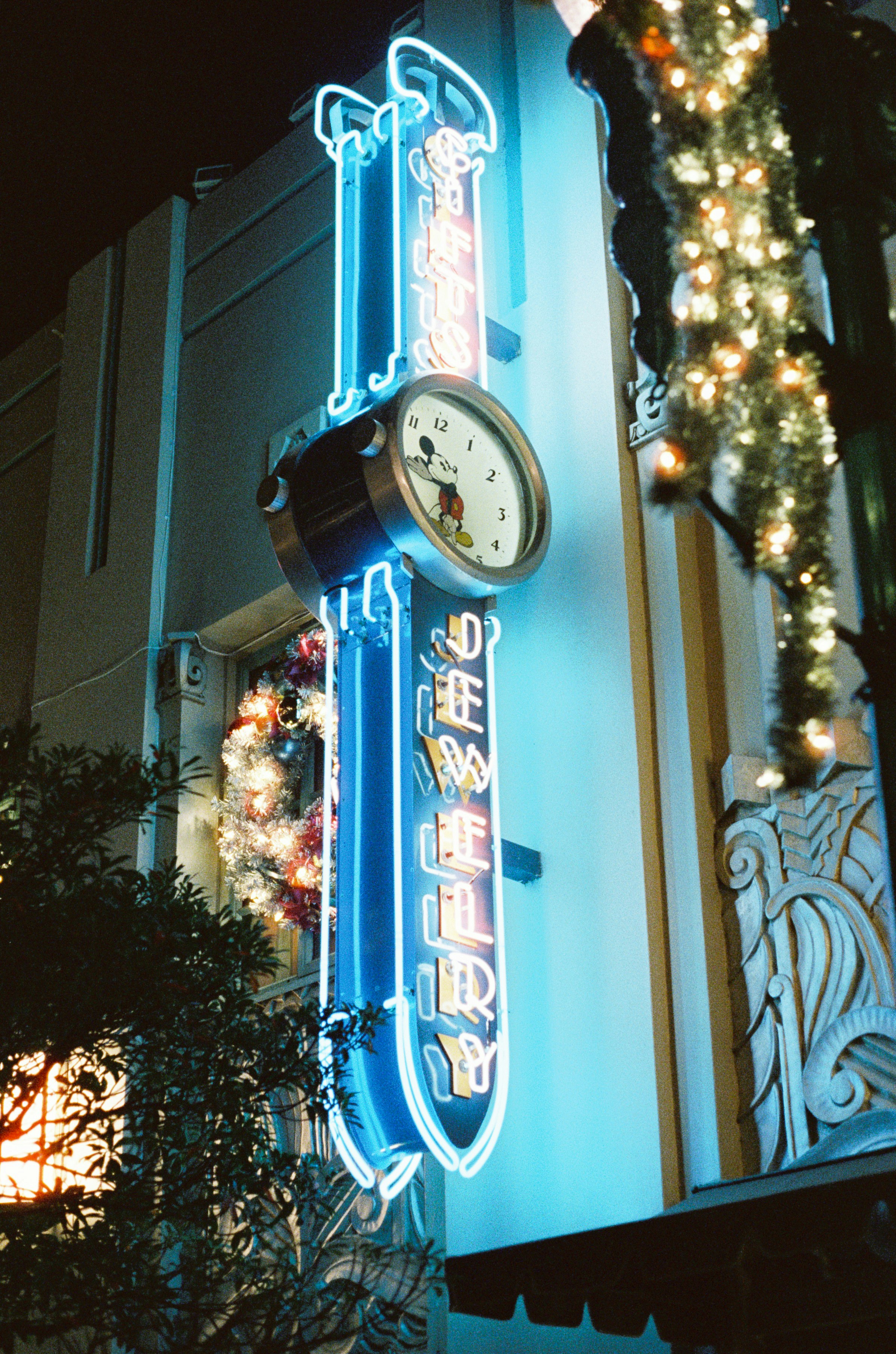 Neon-lit clock tower with mickey mouse.