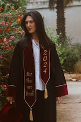 Graduating woman in academic attire looking away.