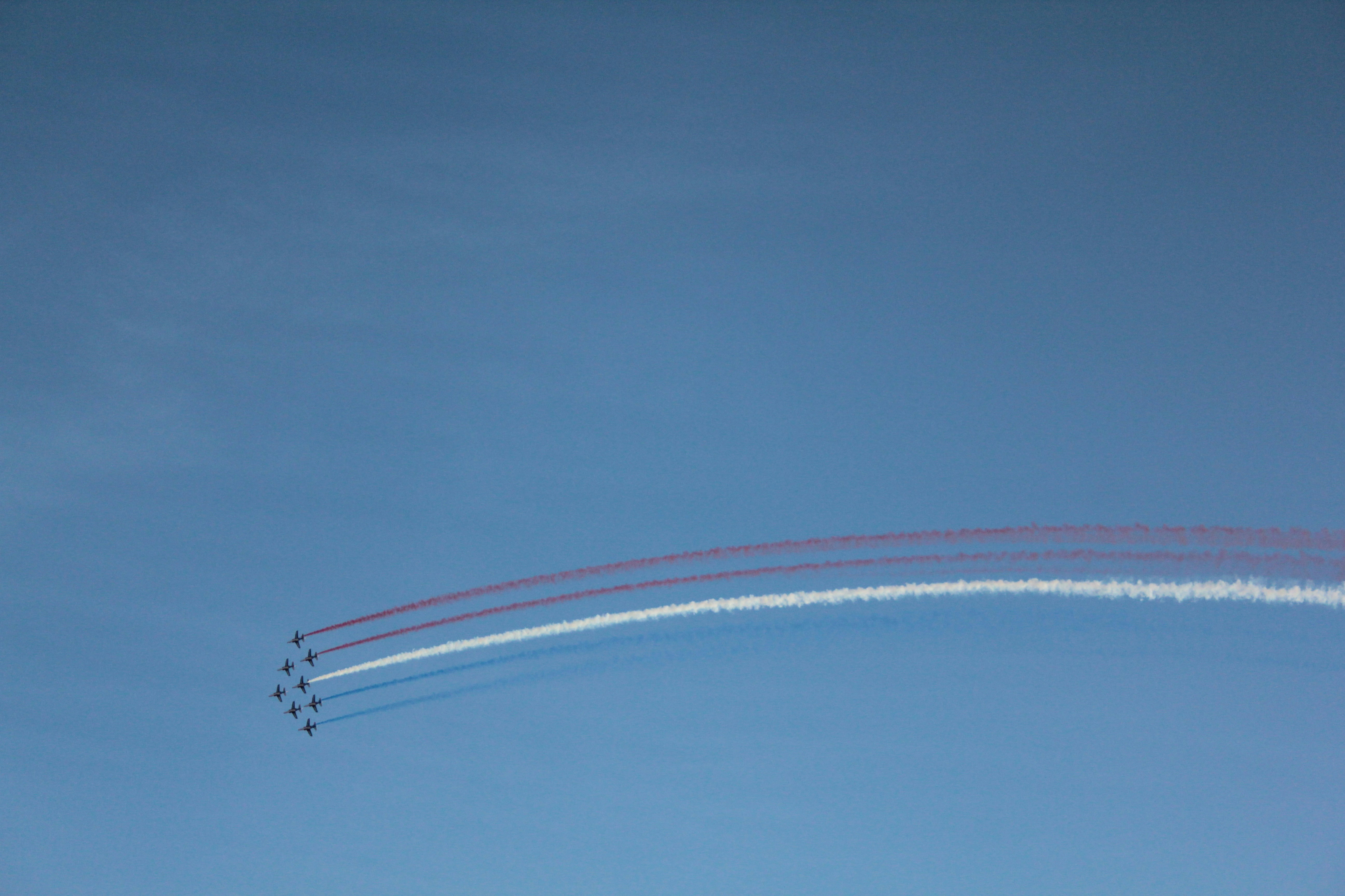 Jets perform acrobatic stunts leaving smoke trails.