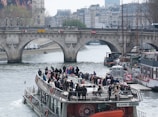 A boat filled with tourists sails on a river.