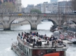 A boat filled with tourists sails on a river.