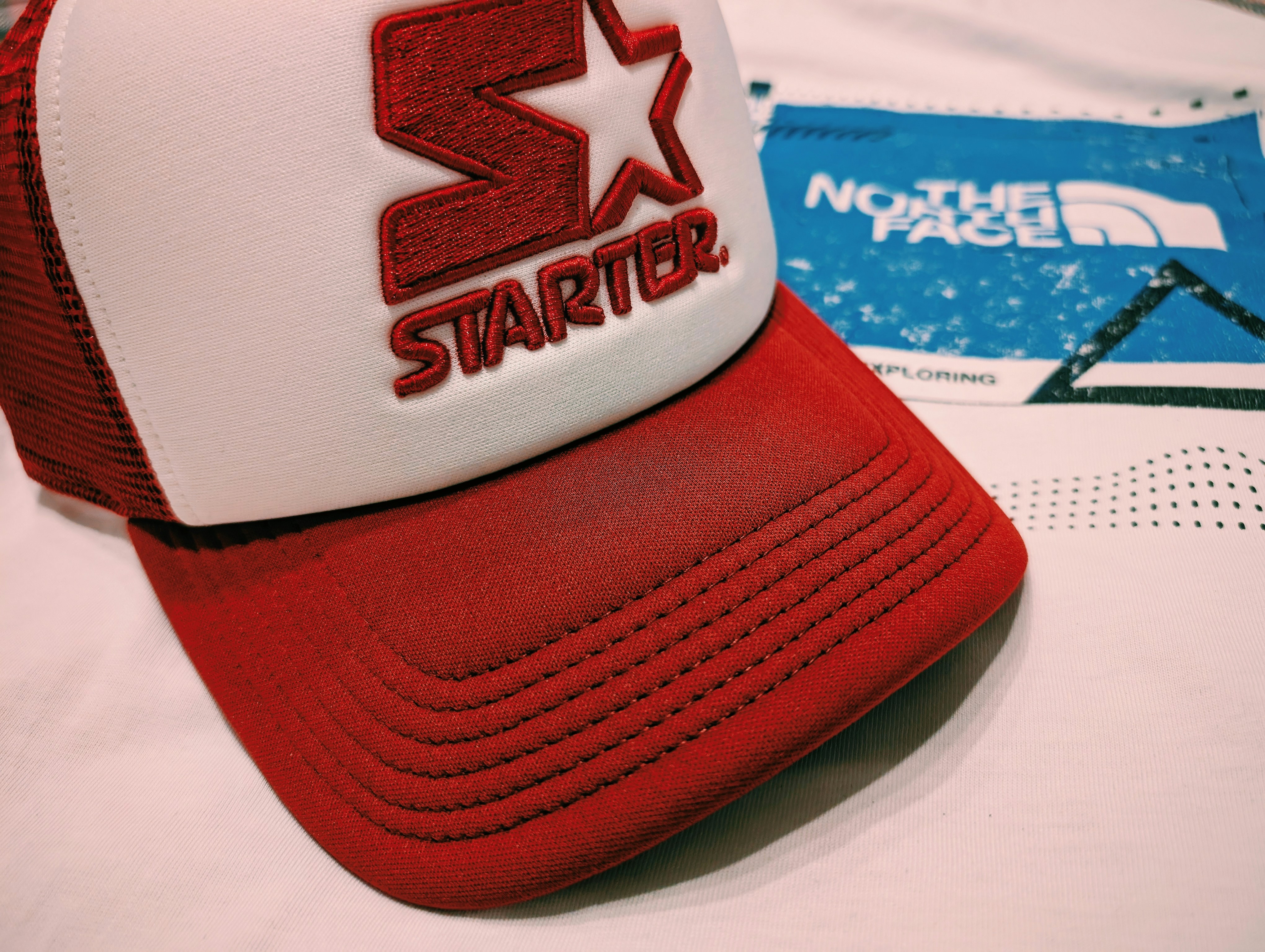 A starter hat rests beside the north face branding.