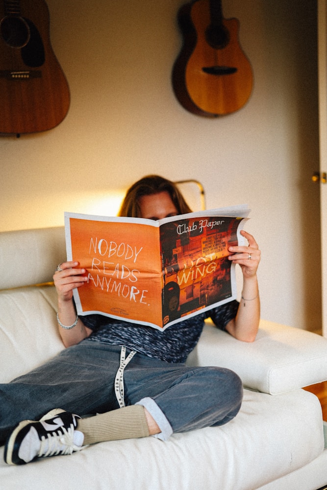 A resident reading a print copy of a local magazine at home