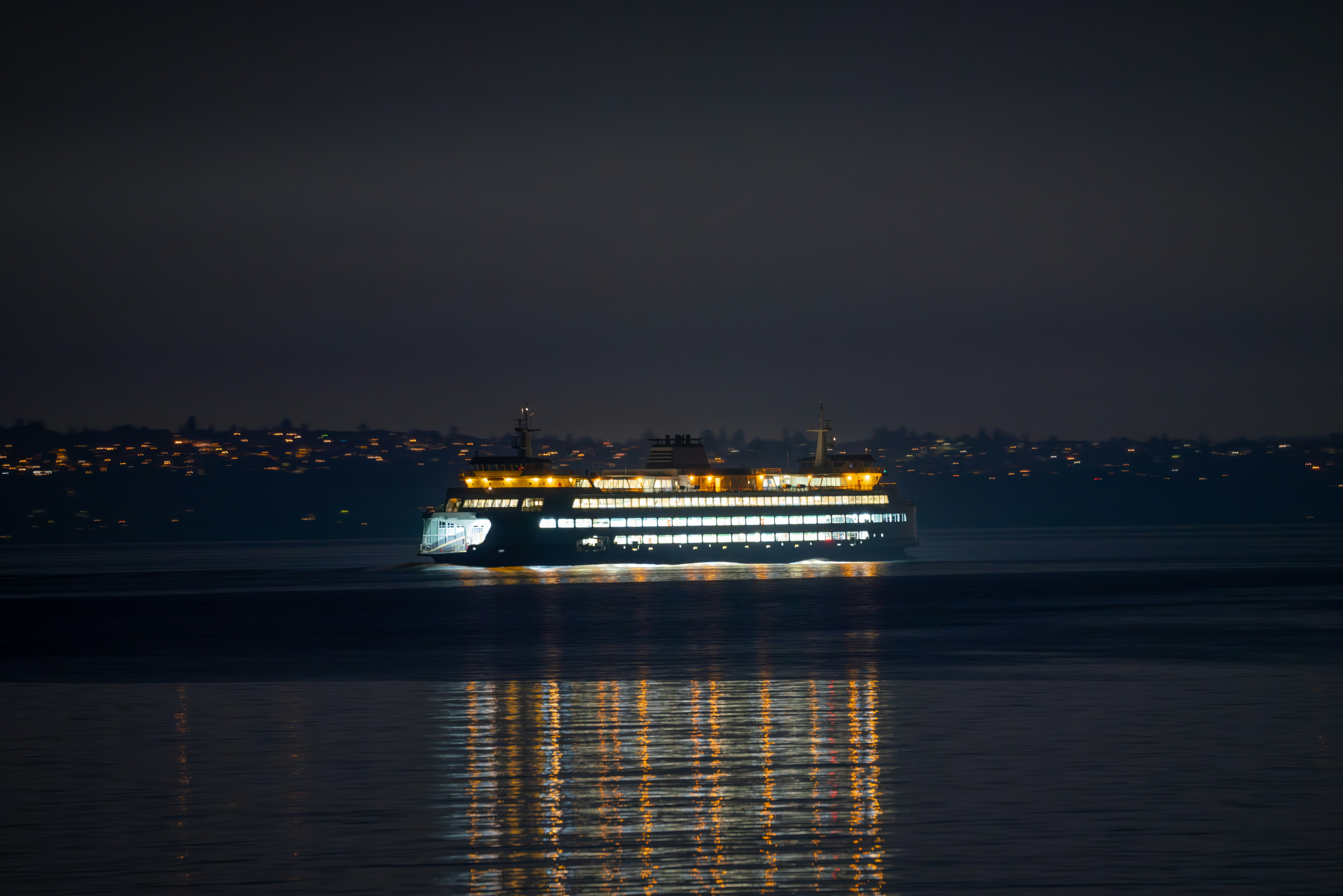 A ferry sails across water at night.