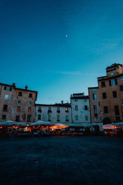 Evening scene in a european square with a crescent moon.
