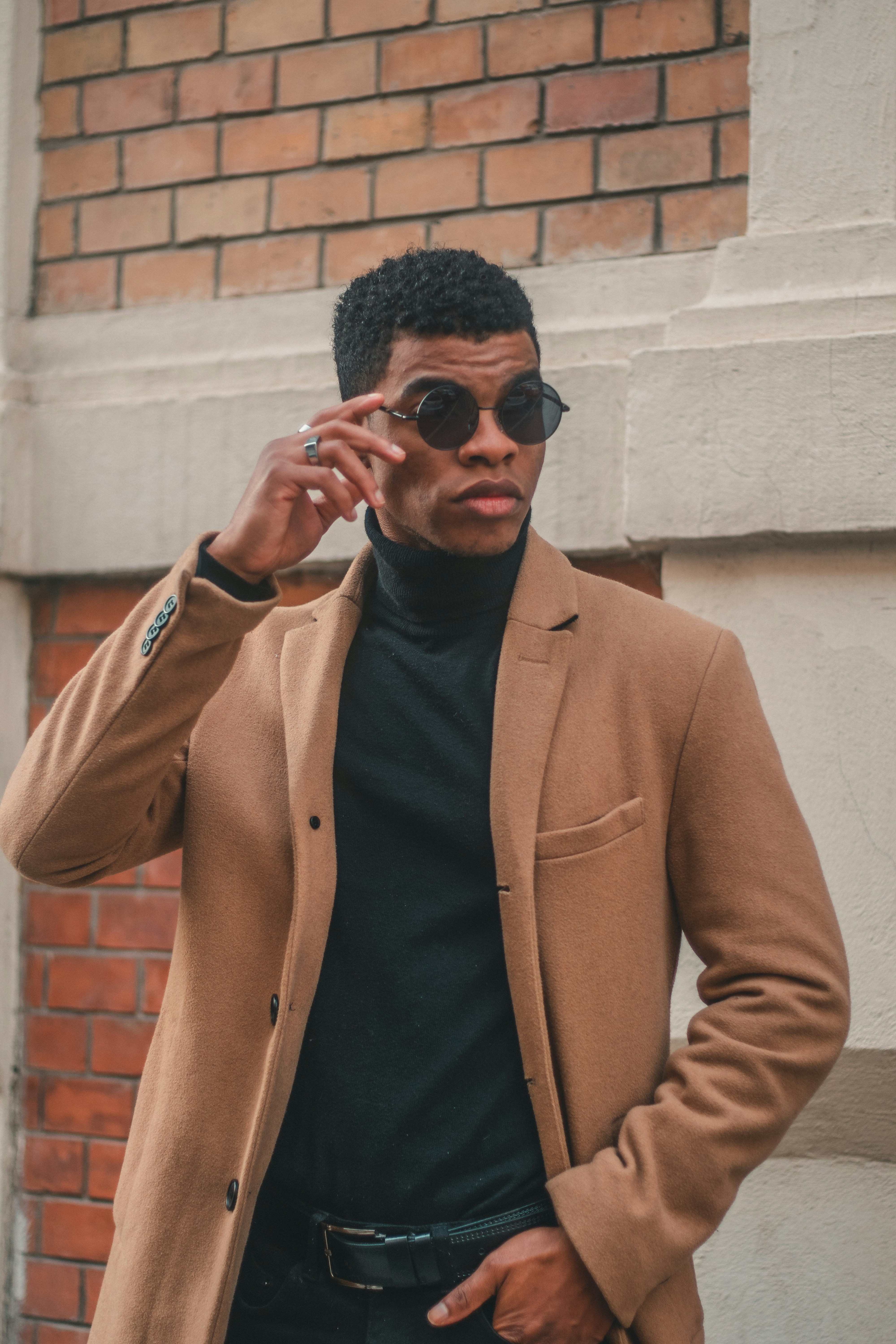 Ein stilvoller Mann posiert mit Sonnenbrille.