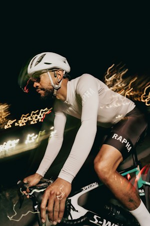 Cyclist riding through the dark with blurred light trails from bike lights