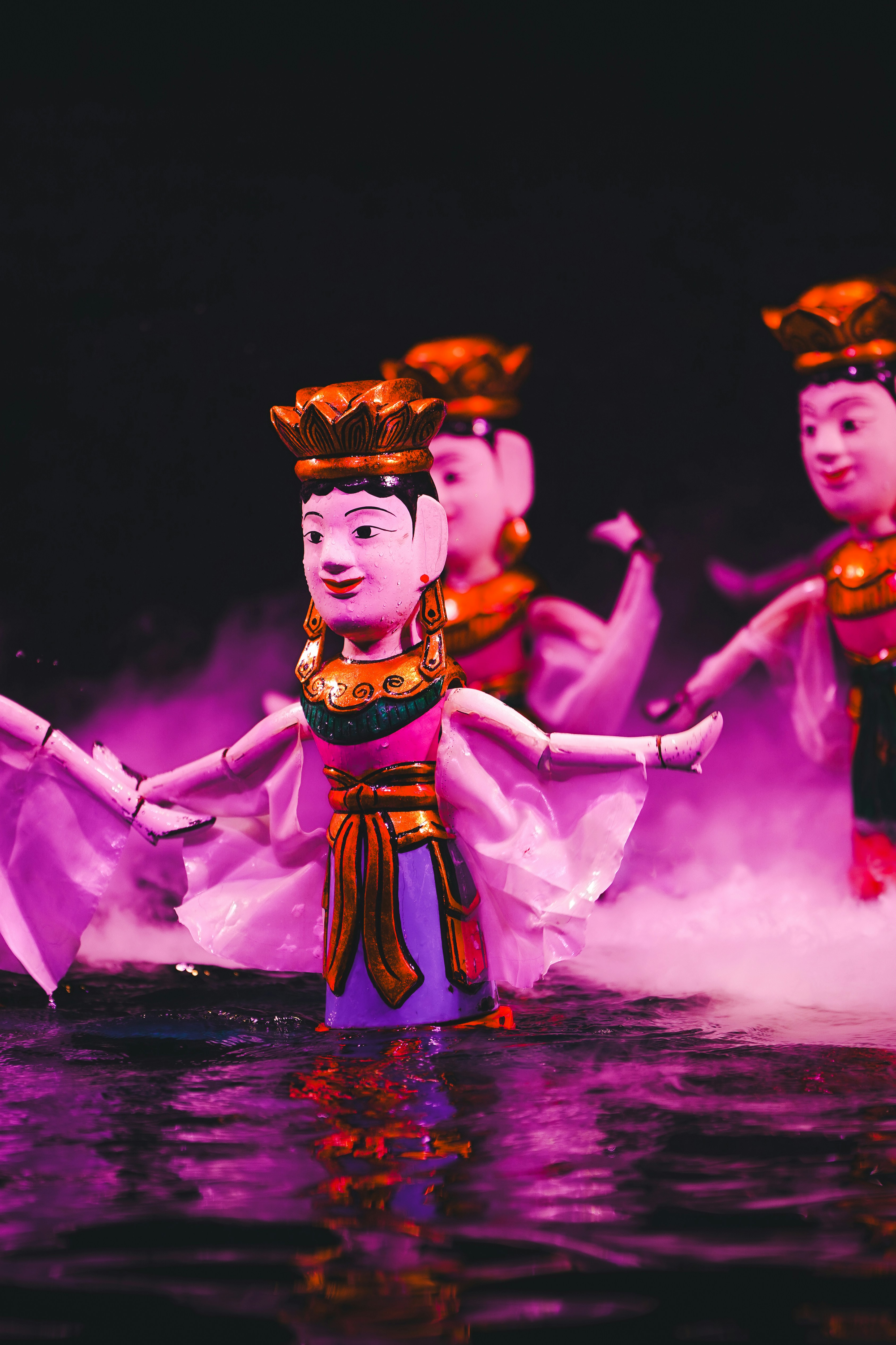 Water puppets perform on a stage.