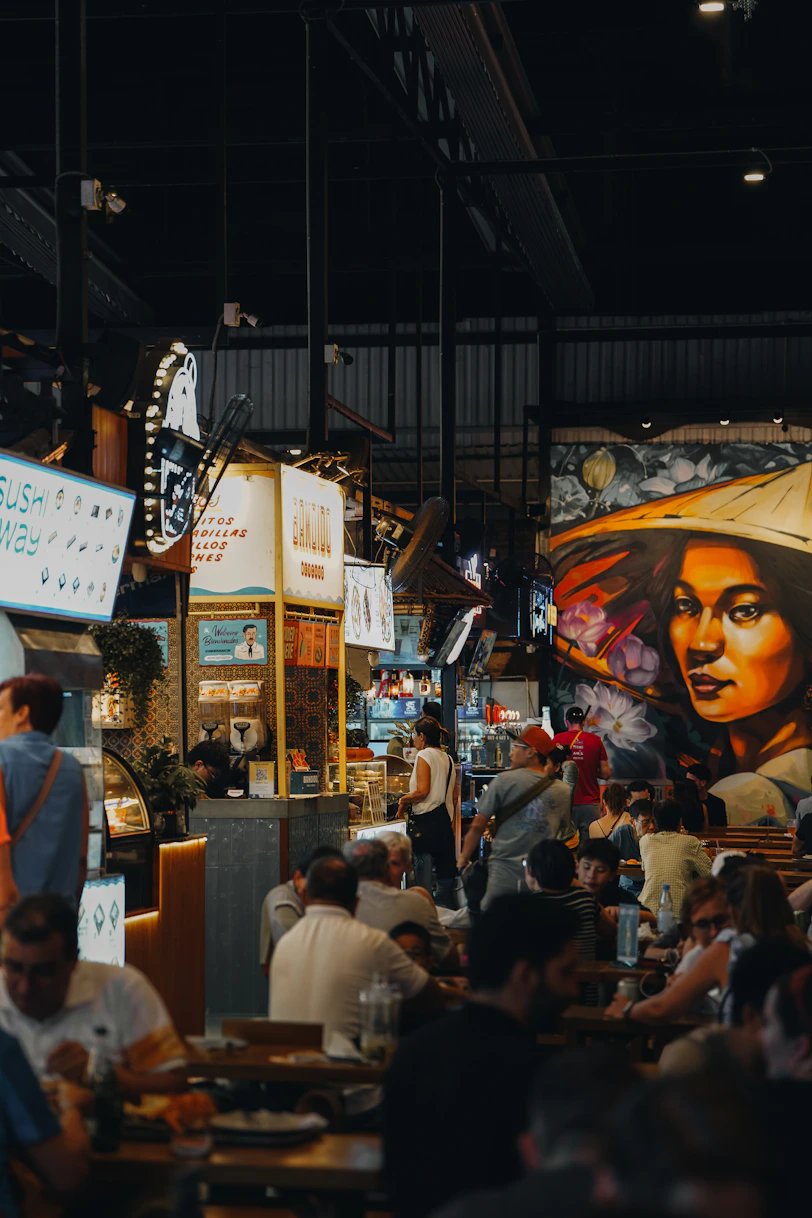 People dine at a busy food market.
