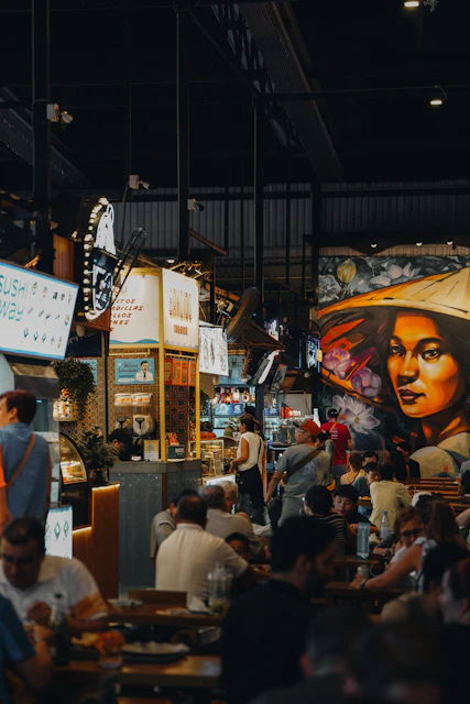 People dine at a busy food market.