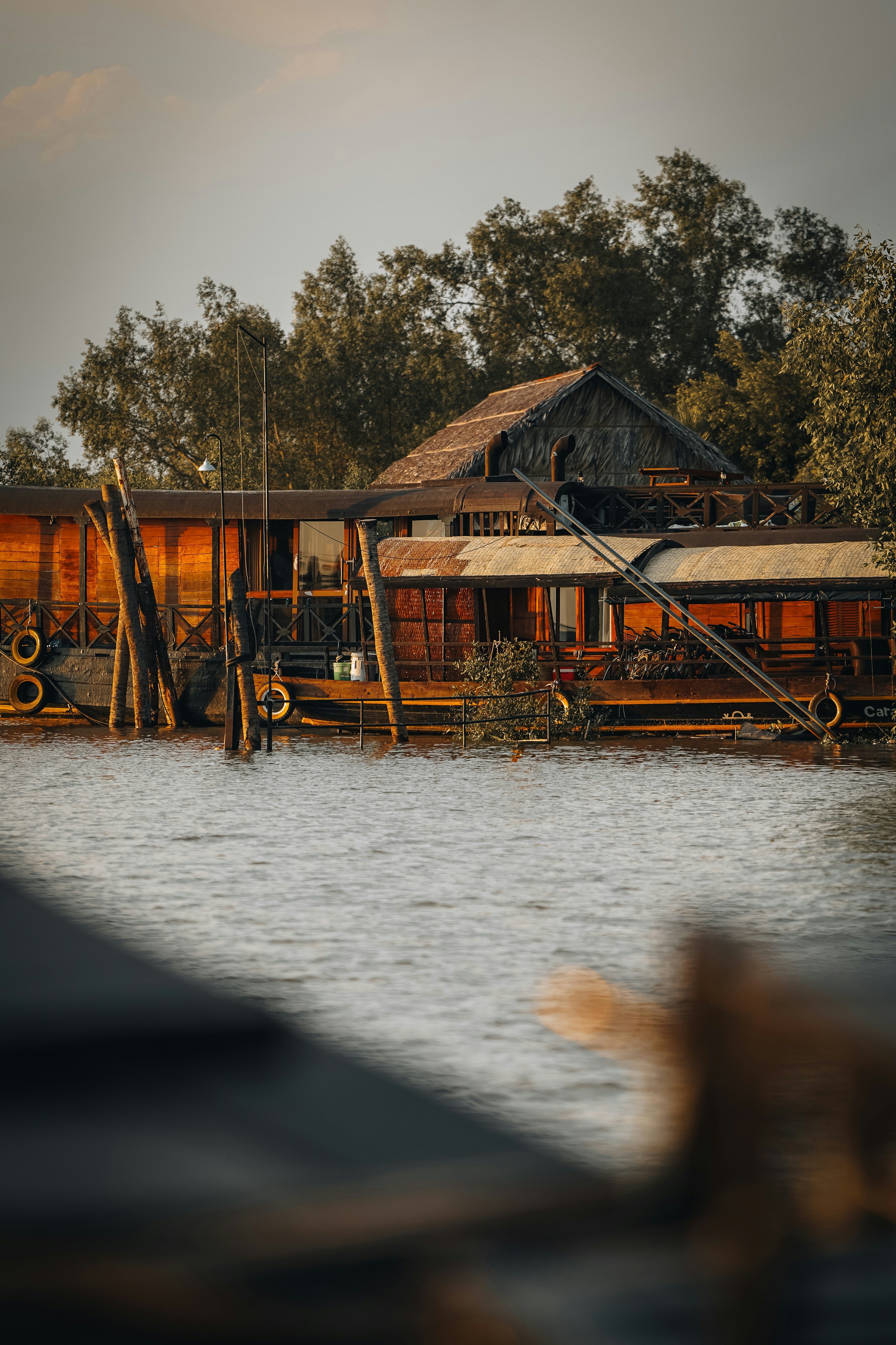 Una casa galleggiante arrugginita riposa vicino all'acqua.
