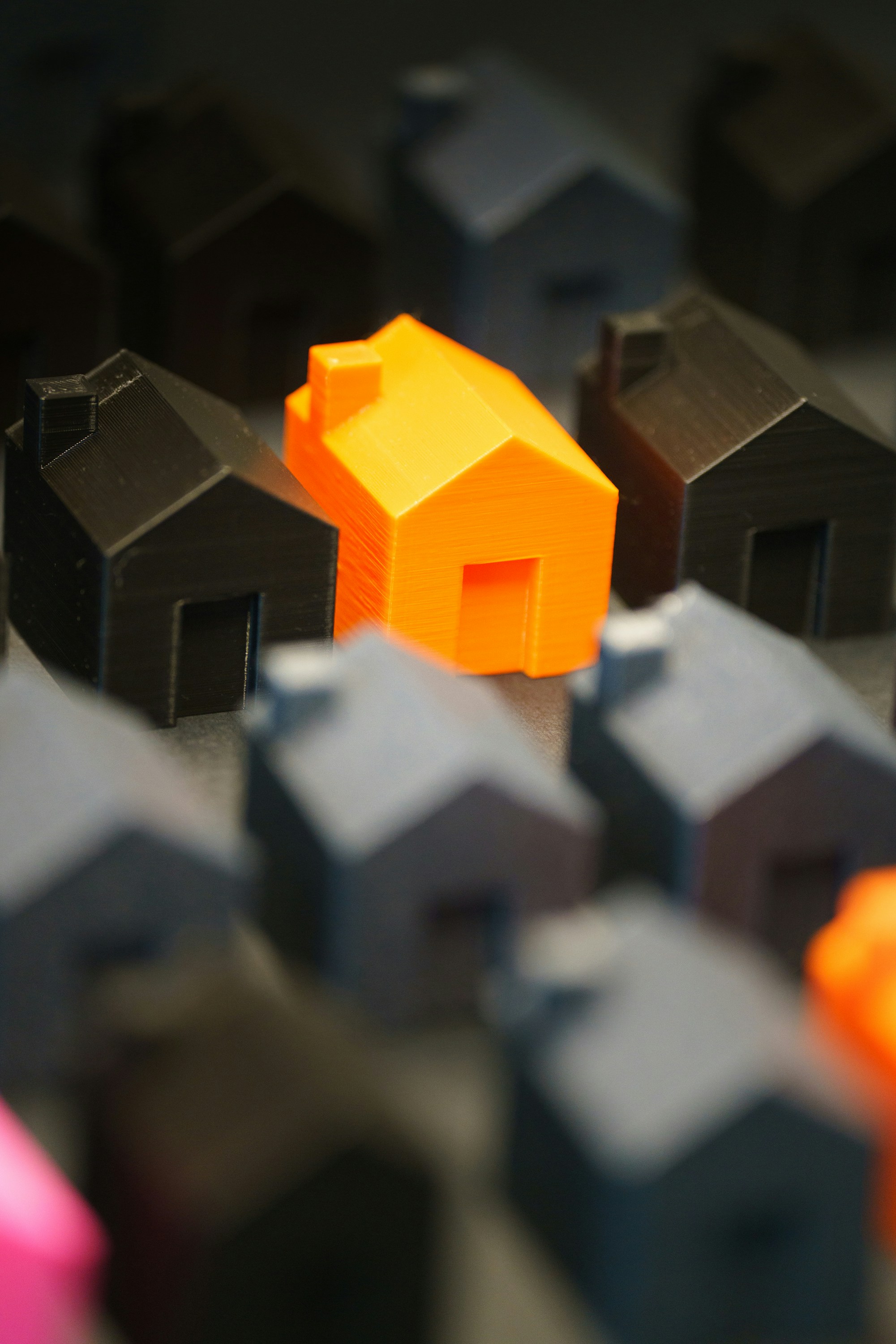 An orange house stands out among gray and black ones.