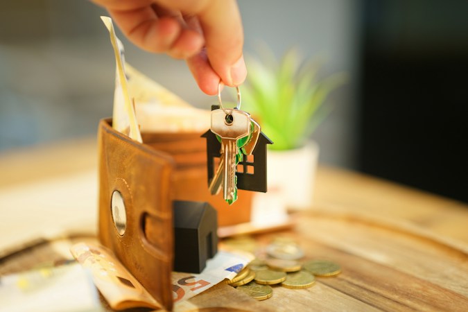 A hand holding house keys with a small house charm next to a wallet, a reminder for Las Vegas buyers to get pre-approved before the Oct. 4 to 10 best week