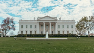 The white house stands under a bright sky.