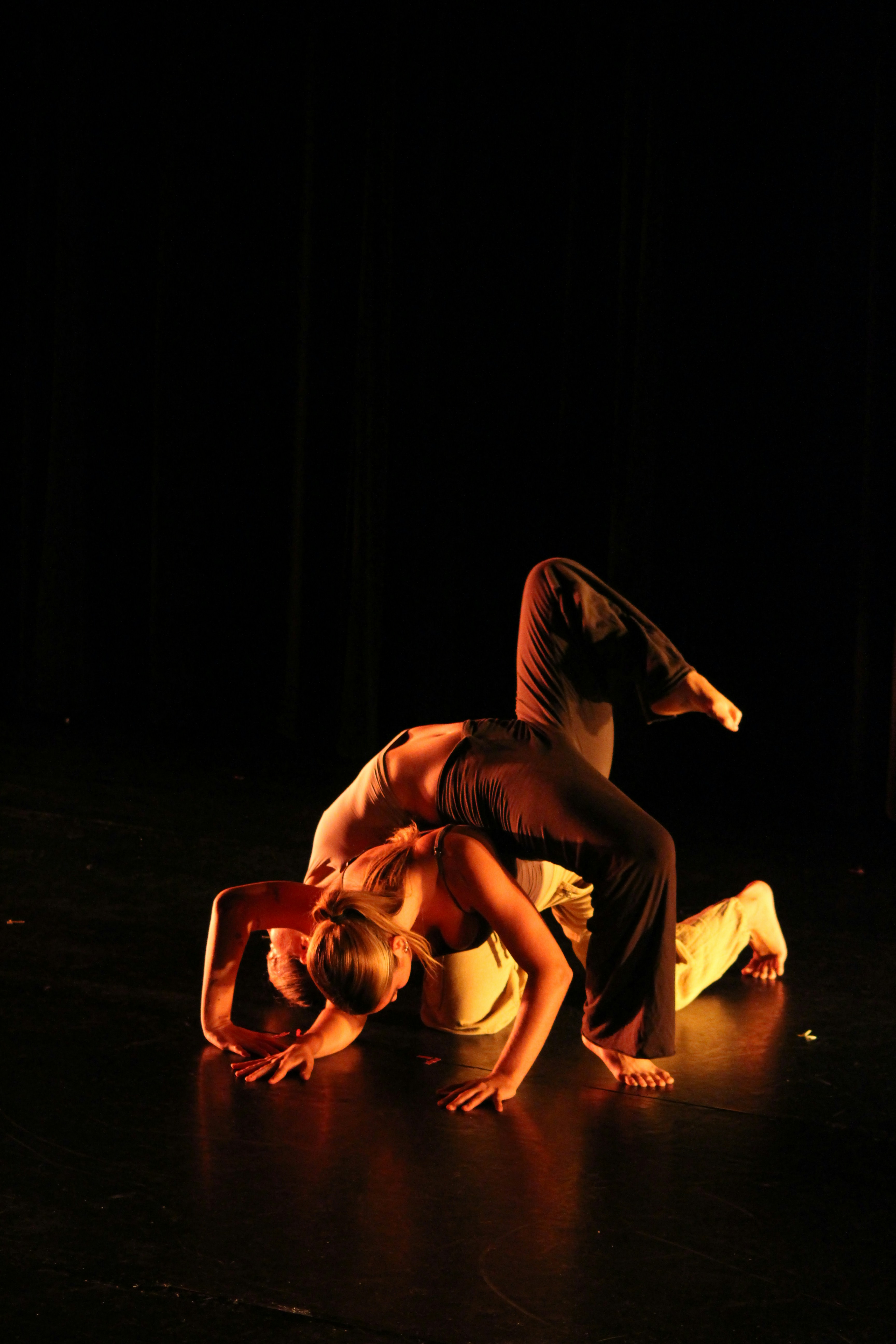 two dancers performing a synchronized move on stage