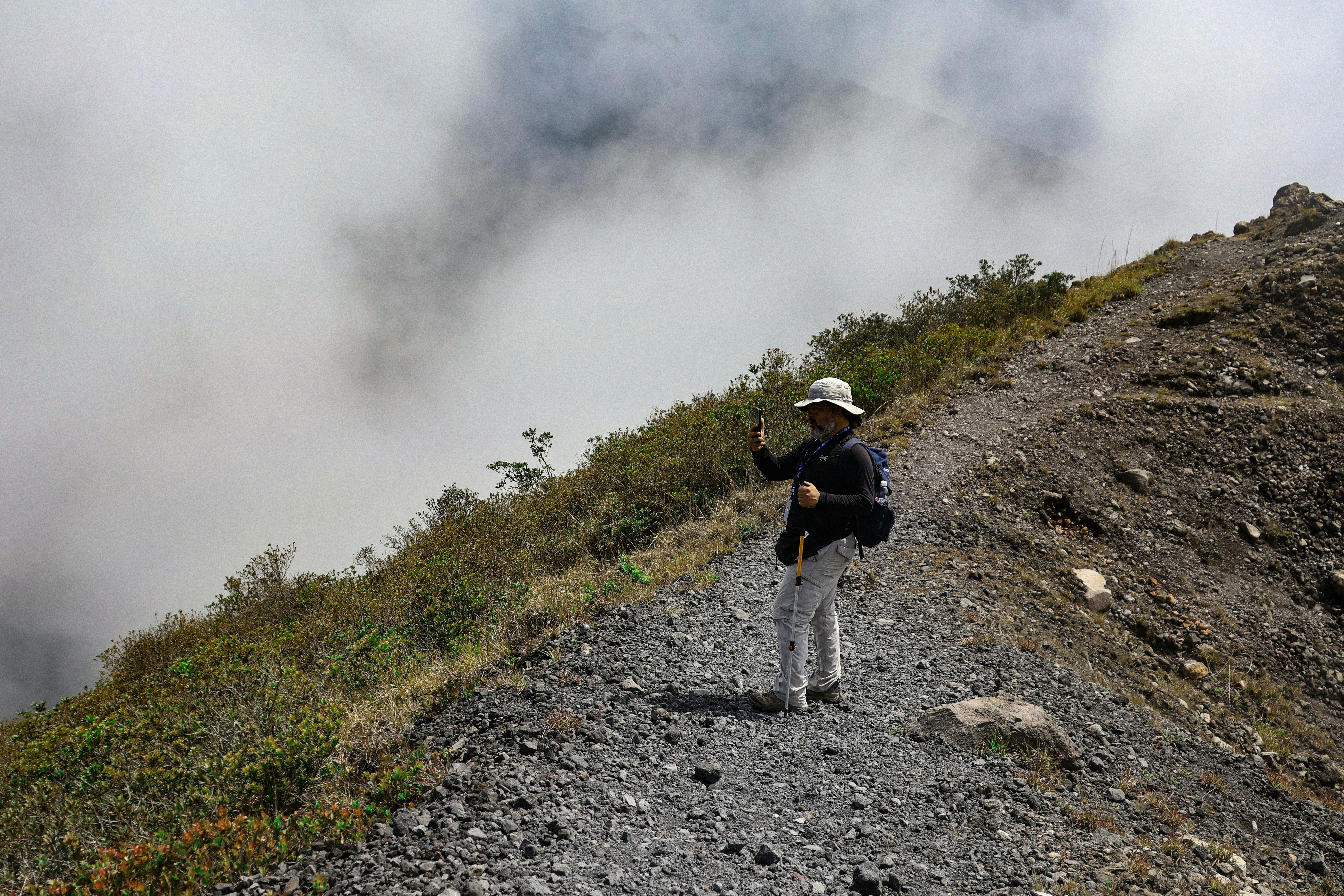 Person poses for a photo on a mountain ridge.
