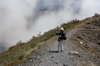 Person poses for a photo on a mountain ridge.