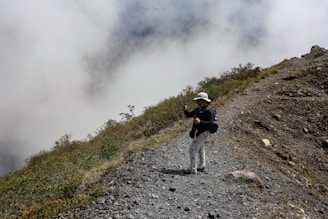 Person poses for a photo on a mountain ridge.