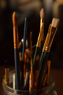 Paintbrushes fill a jar, ready to create.