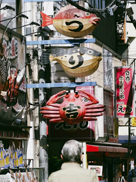 Signs shaped like seafood hang over a street.