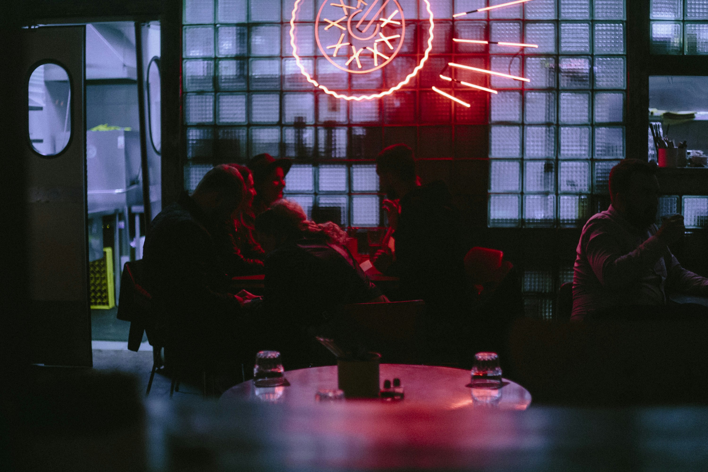 People gather inside a dimly lit establishment.