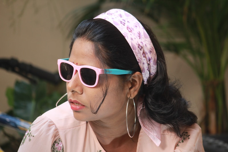 Woman is wearing sunglasses, headband and hoop earrings.