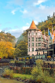A beautiful building stands amidst autumn trees.