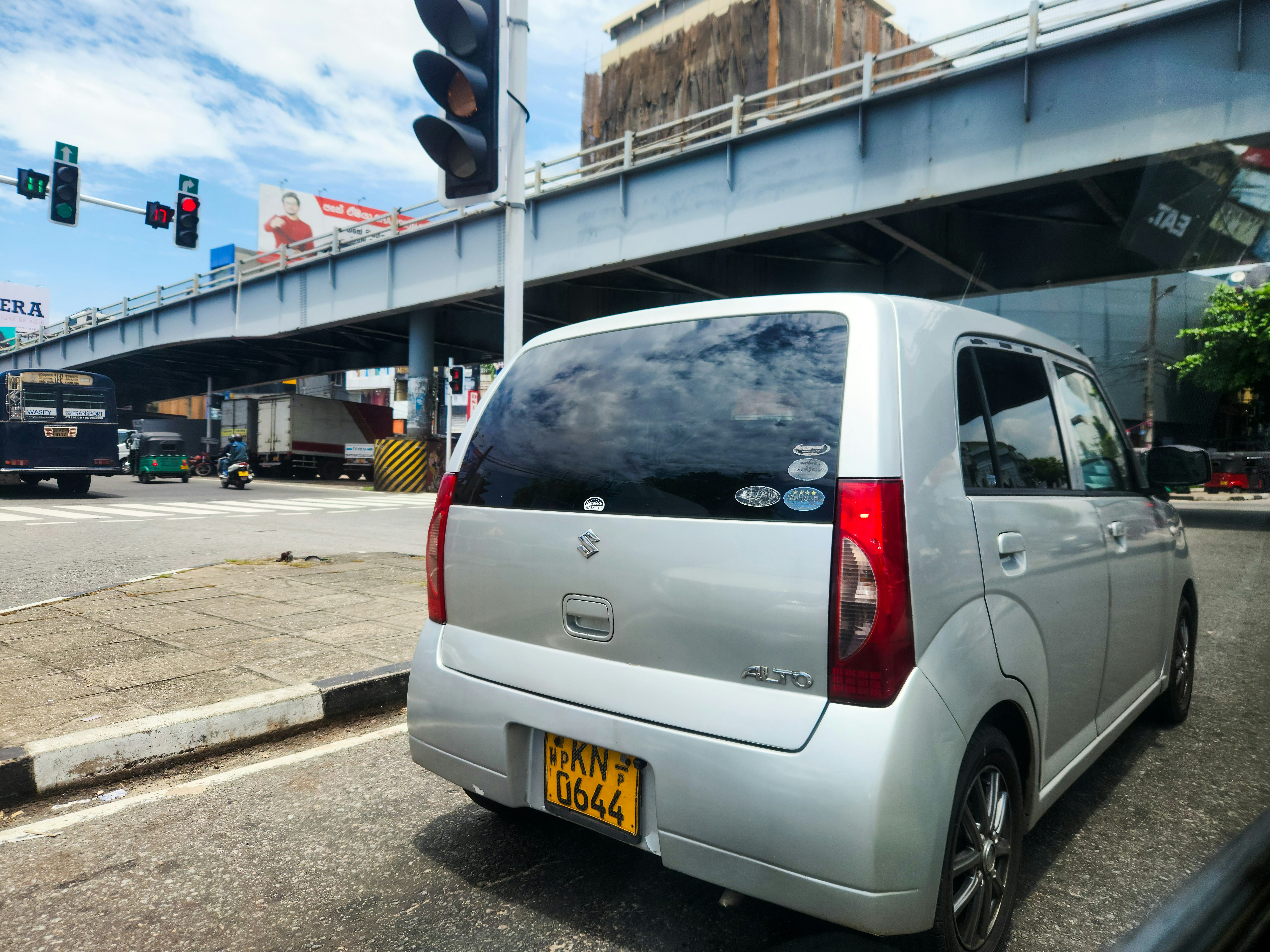 A silver car waits at a traffic light.