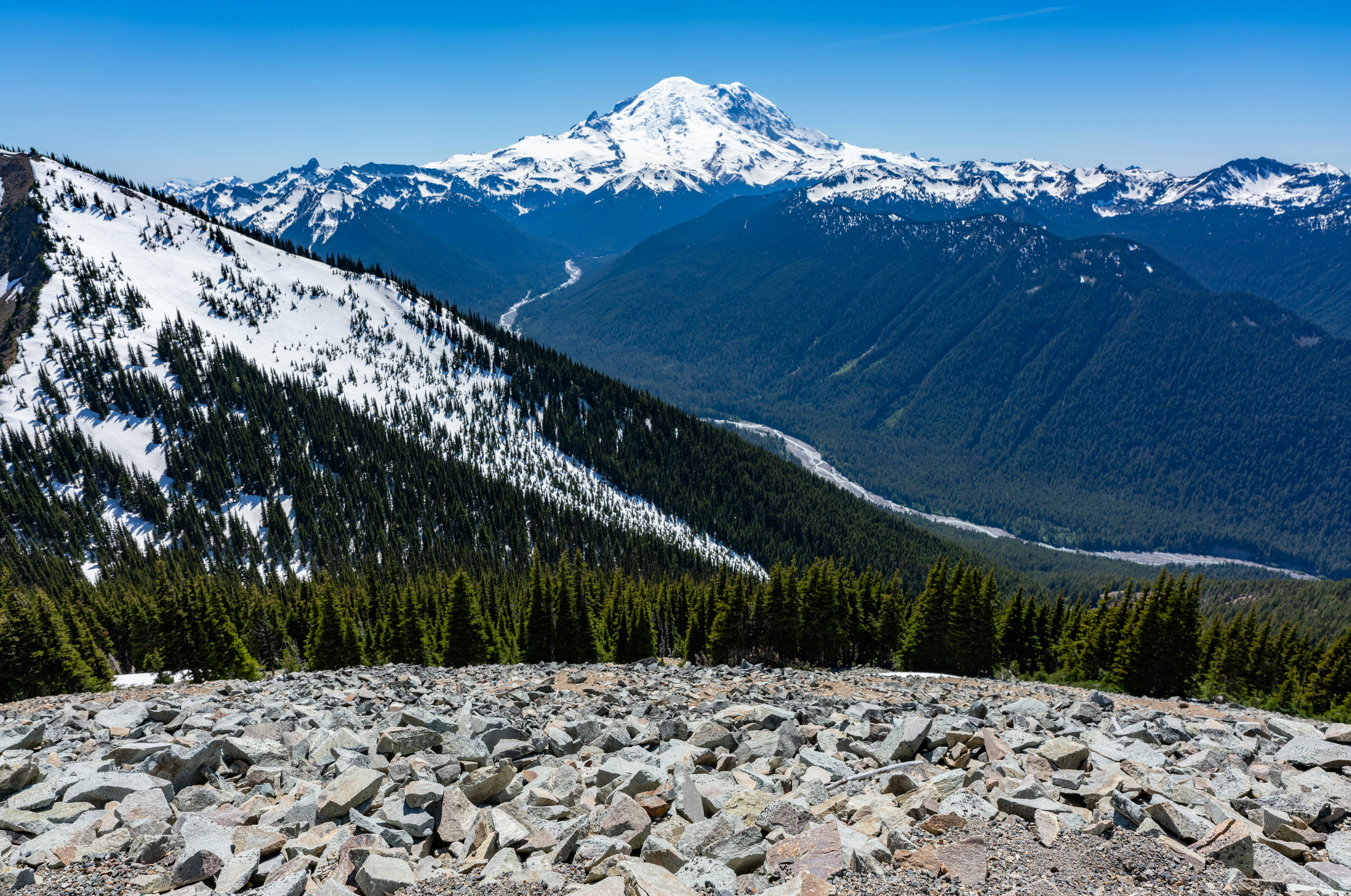 Snowy mountains tower over a valley.