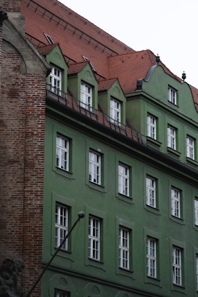 A green building has many windows.