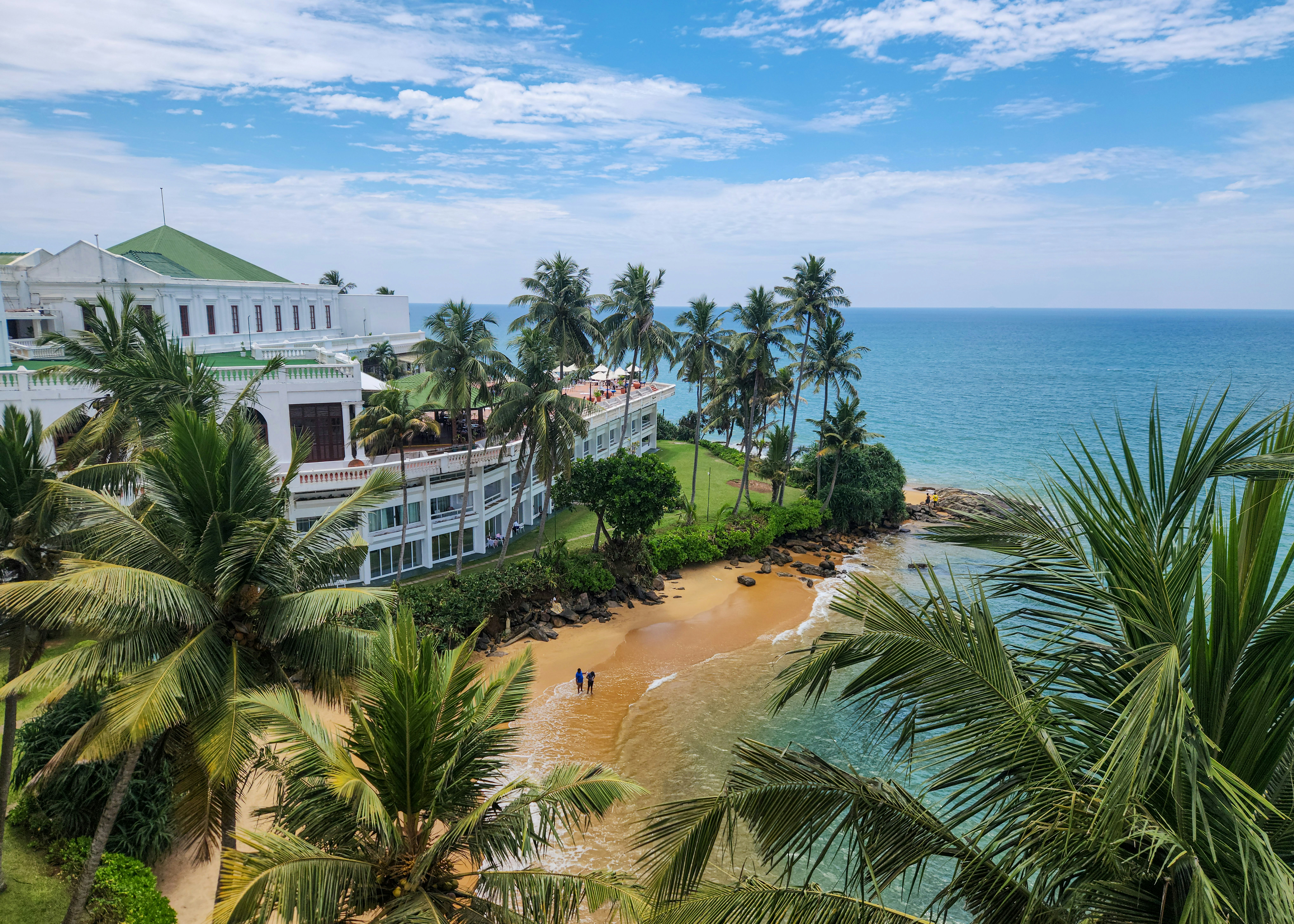 Beautiful beach with buildings and palm trees.