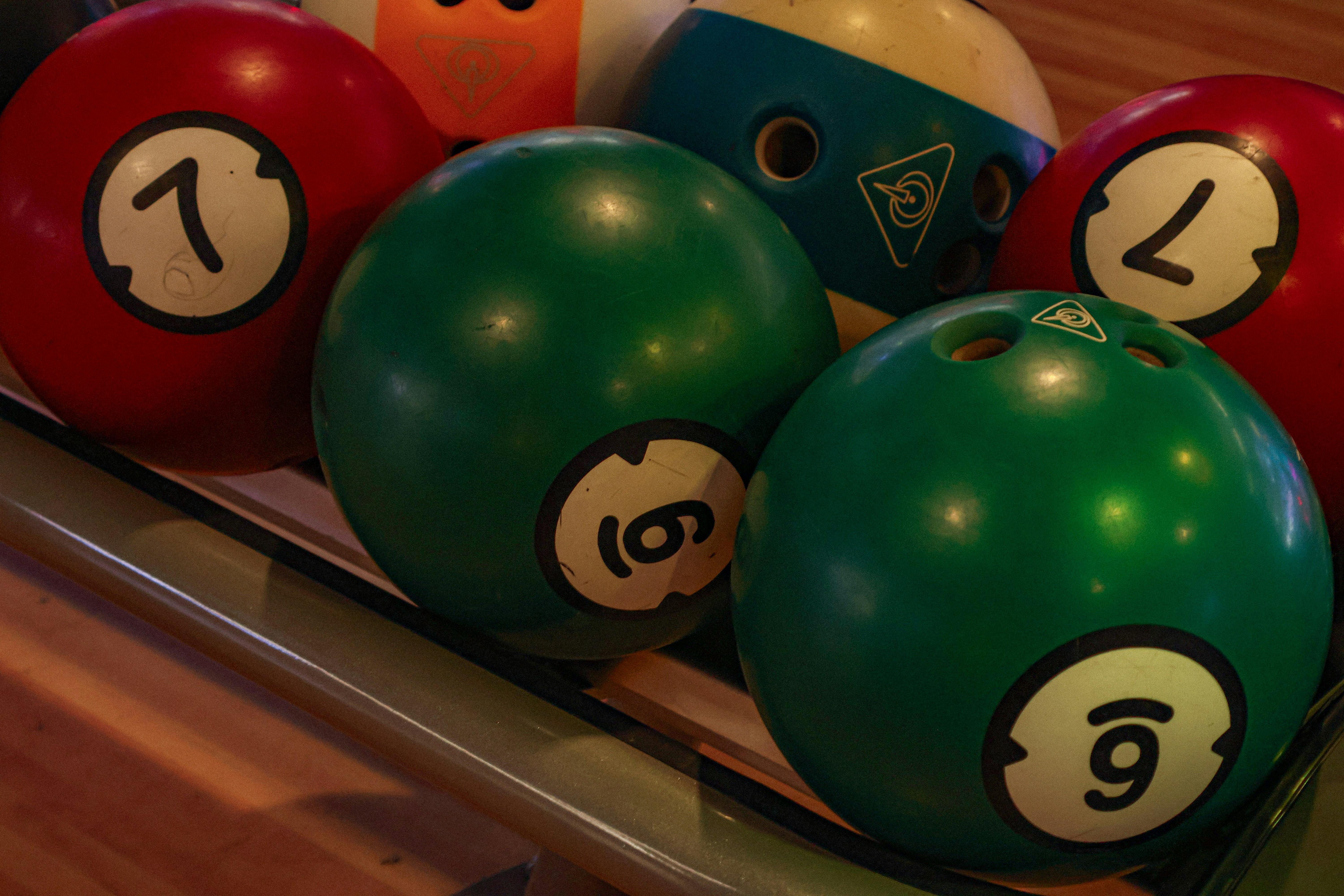 Bowling balls with various numbers are shown.