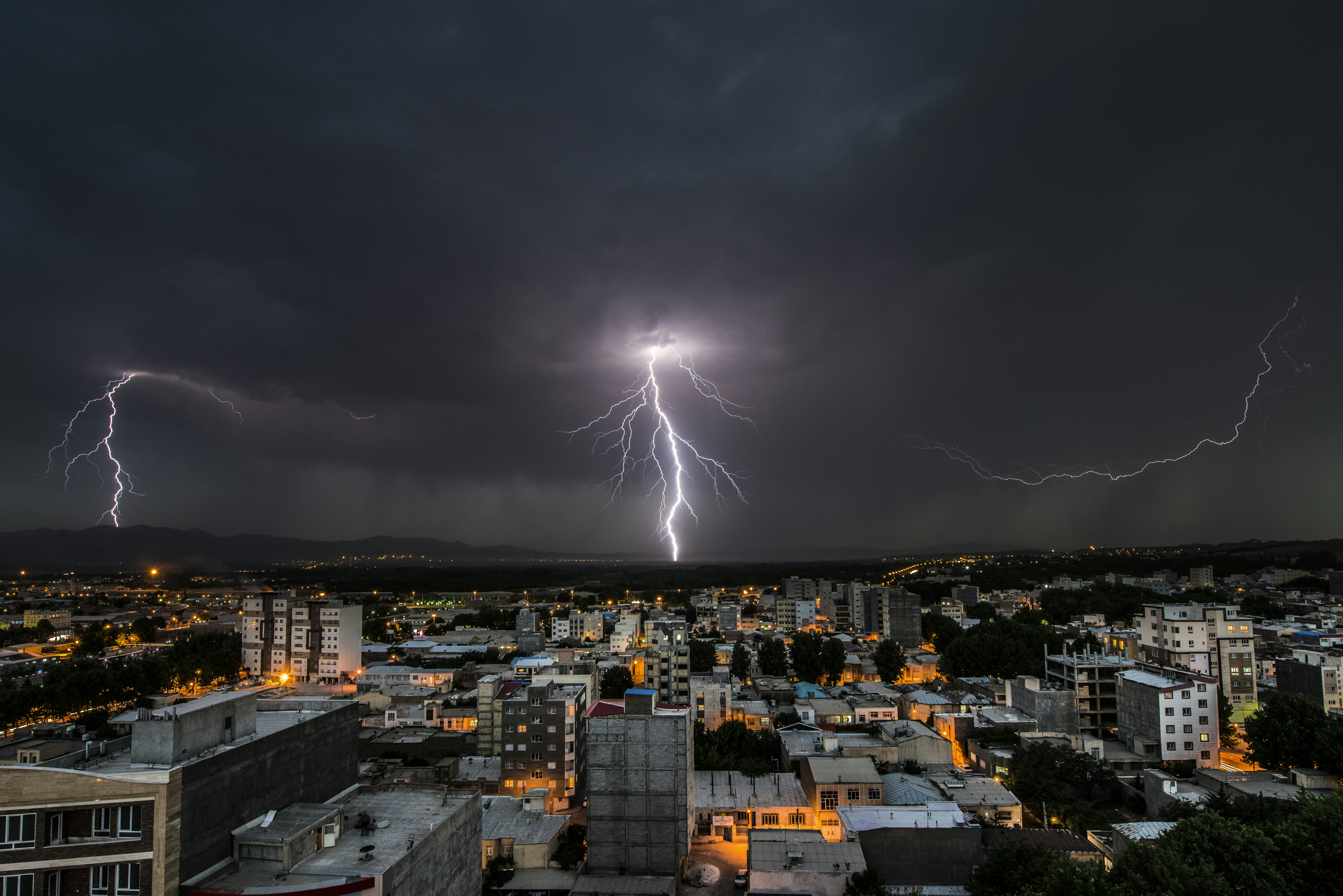 Um raio cai sobre uma cidade à noite.