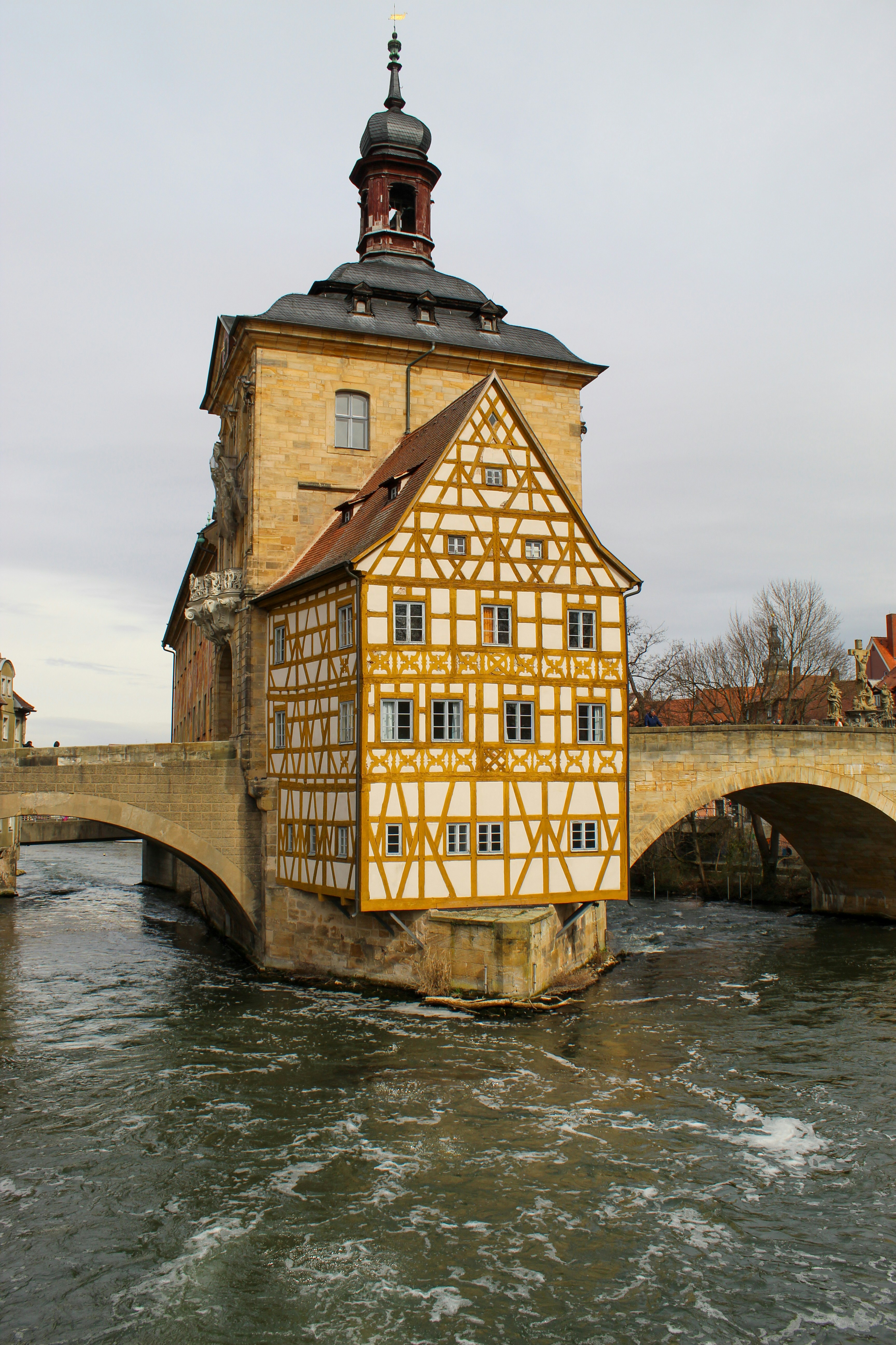 A medieval building sits on a river bridge.