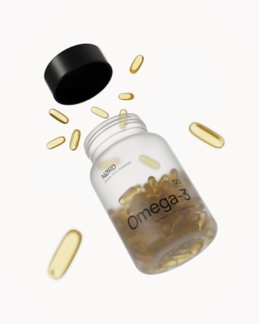 Omega-3 capsules spilling from their bottle.