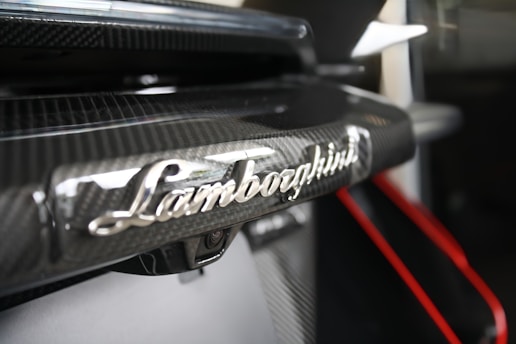 Lamborghini logo on a carbon fiber car.