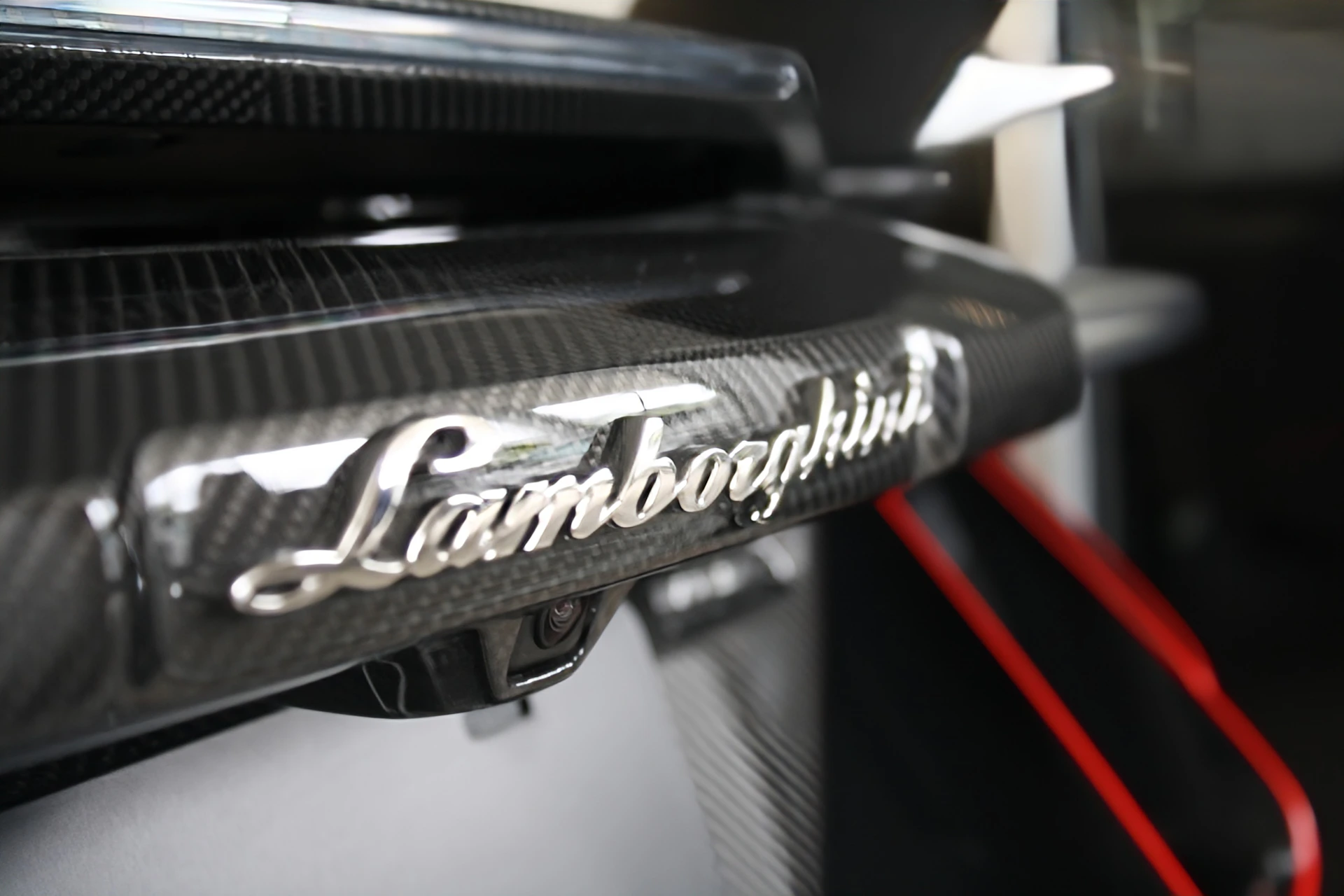 Lamborghini logo on a carbon fiber car.
