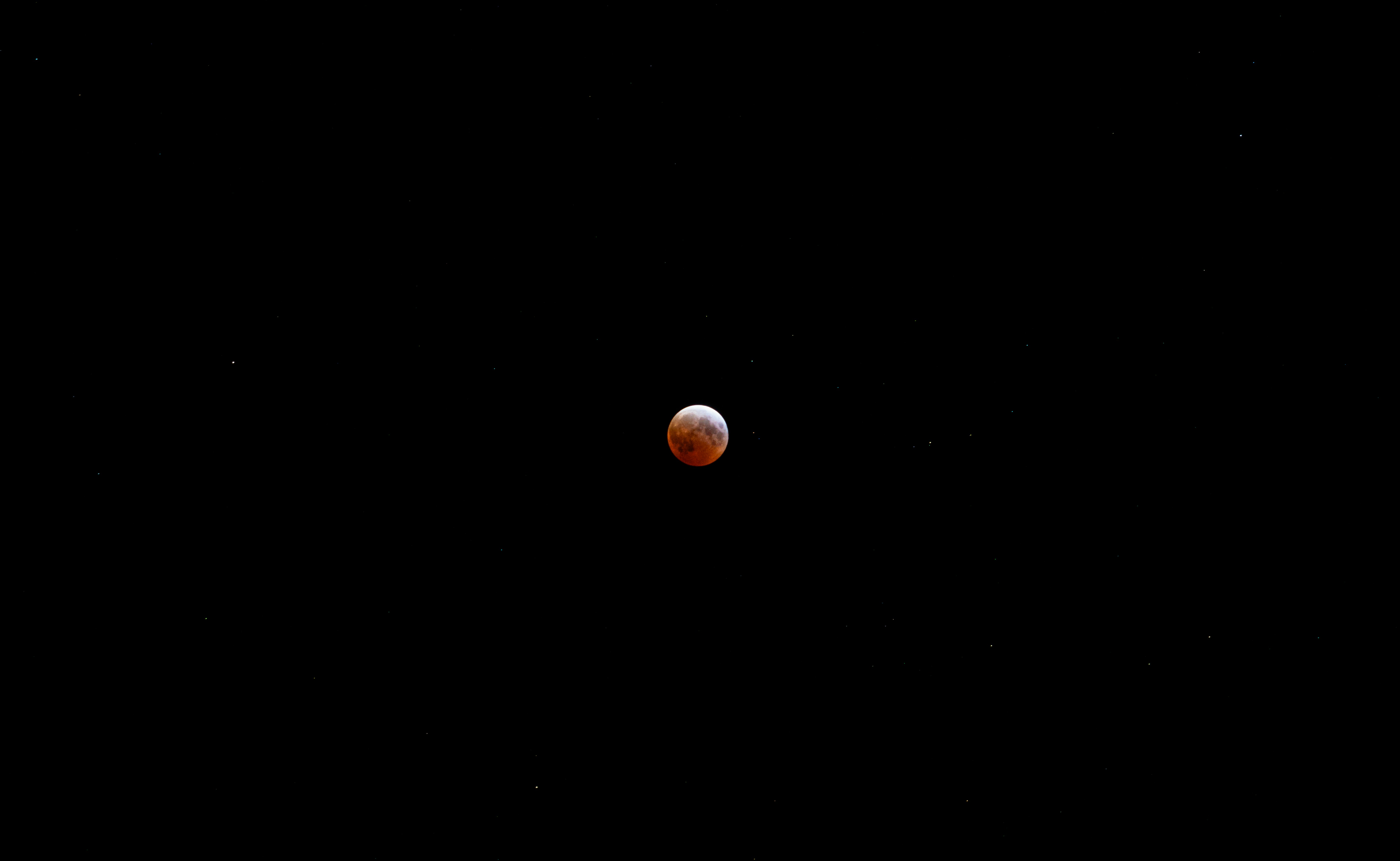 A red moon is visible against the black night.