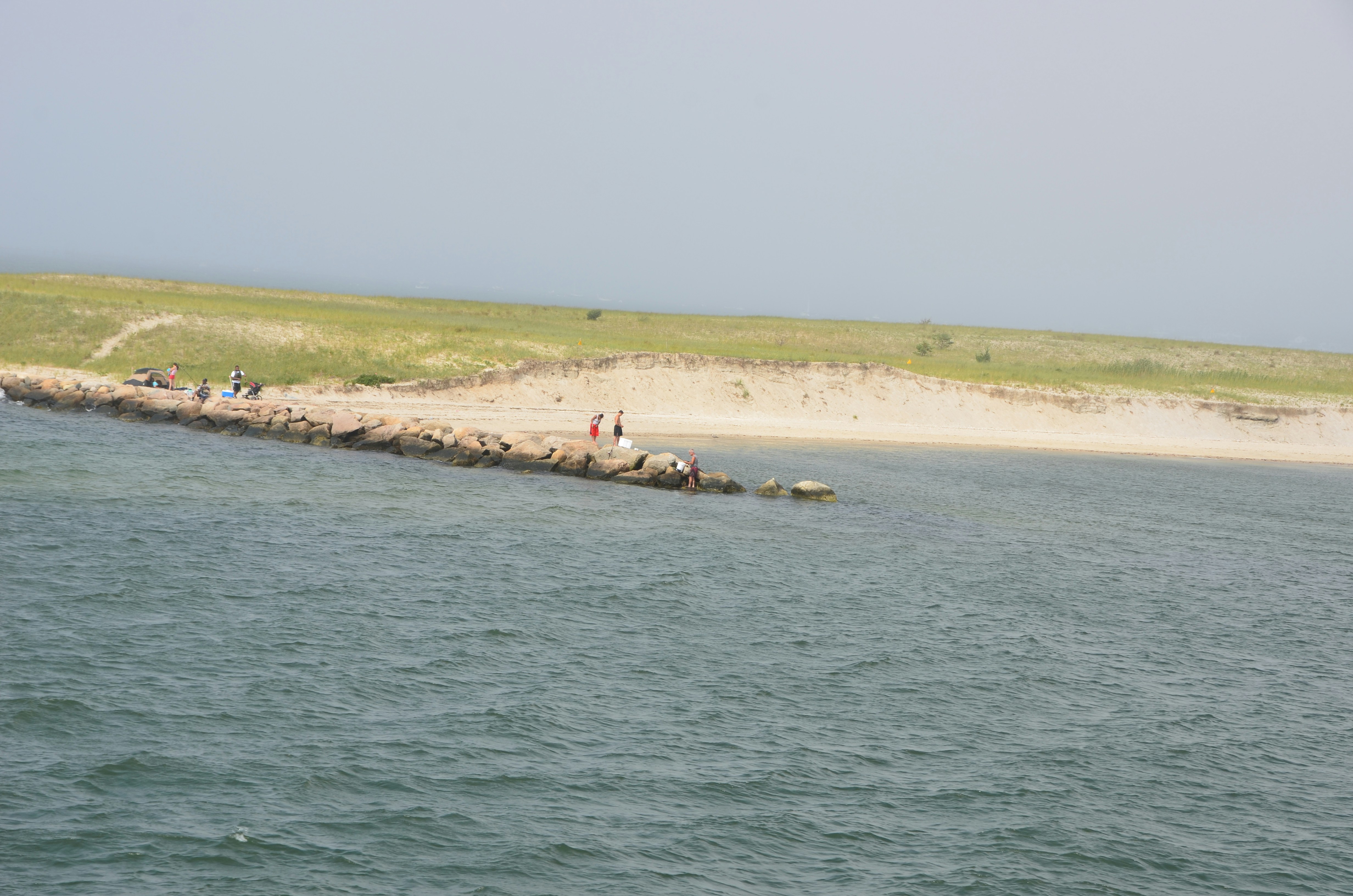 Image of a shoreline protected by a bulkhead with visible tie-back anchors - what is the proper technique for anchoring