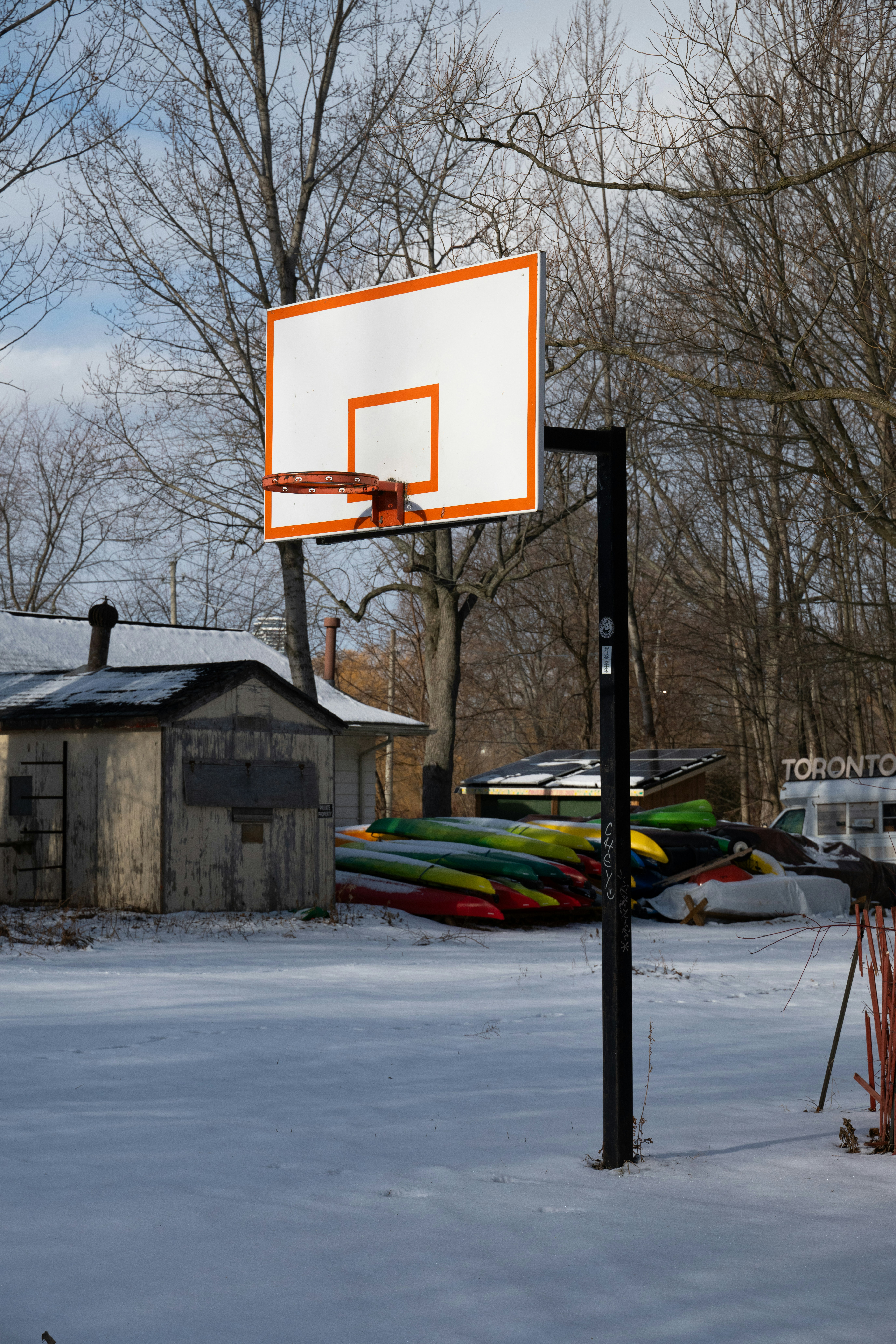 A basketball hoop stands in a snowy yard.
