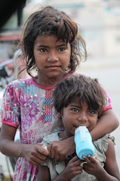 Two children in need stand together.